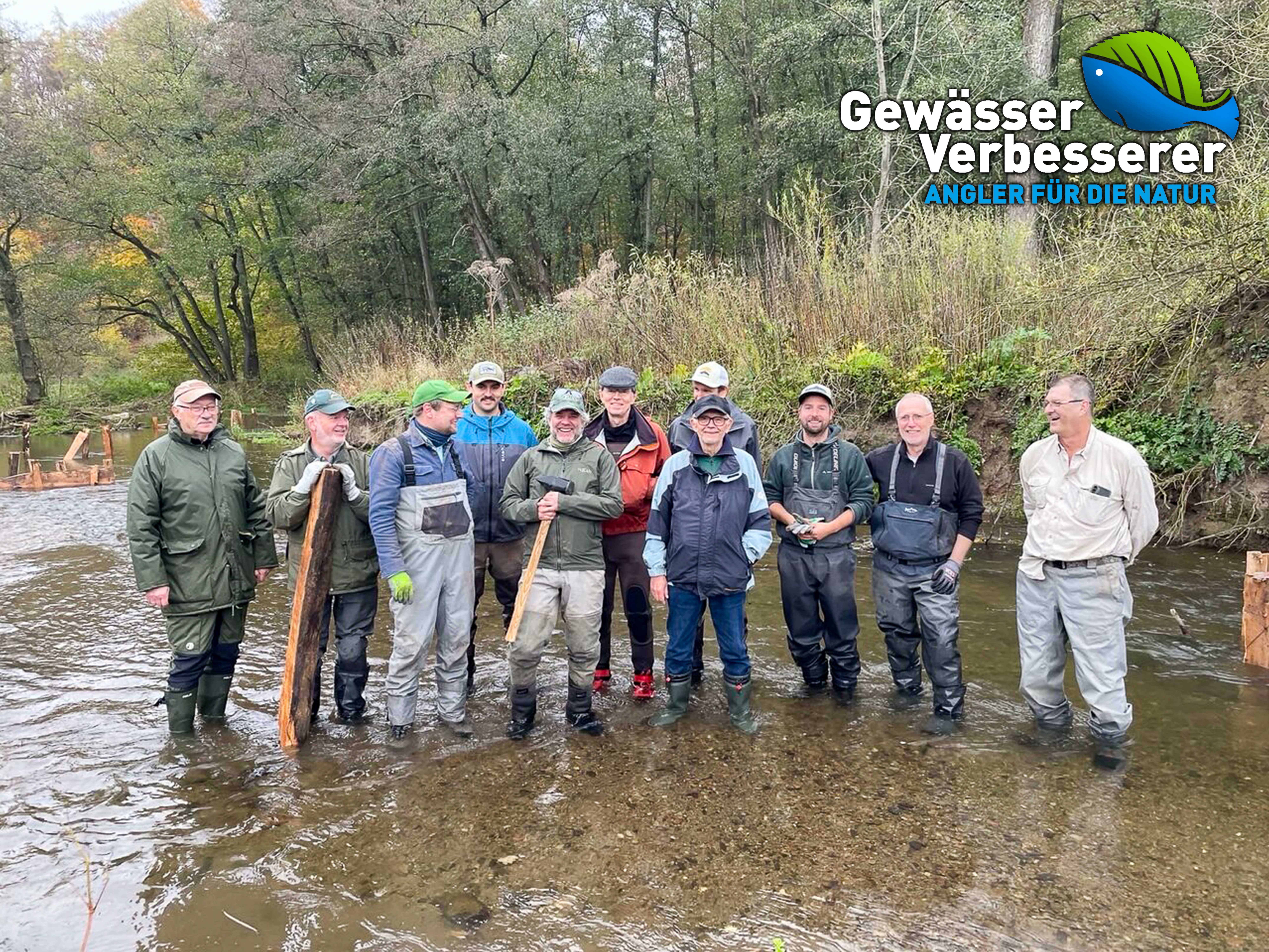 Eine Gruppe von Personen steht in einem knöcheltiefen Fluss